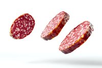 Flying slices of salami sausage isolated on white background, levitating in air with natural shadows, fresh deli meat cuts showing marbled texture and spices.