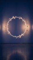 Glowing circular light installation with warm illuminated bulbs arranged in a ring formation against dark blue background, suitable for modern art, technology, and creative design projects.
