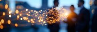 Blurred silhouettes of people against evening sky with bright golden sparkler creating magical light trails and bokeh effect, festive celebration atmosphere.