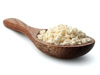 Fresh cottage cheese in wooden spoon isolated on white background. Natural dairy product with soft texture and creamy white color. Healthy protein food.