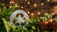 Recycling symbol surrounded by lush green plants and warm bokeh lights creating sustainable living and eco-friendly lifestyle concept for environmental awareness.
