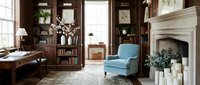 Elegant home office interior with blue armchair, wooden desk, built-in bookshelves, and classic fireplace in warm traditional style.