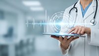 Doctor using digital tablet with holographic heart rate monitor and medical technology interface in modern hospital setting for healthcare innovation.