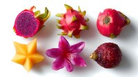 Fresh exotic tropical fruits collection with dragon fruit, star fruit and rambutan arranged on white background, top view composition for food photography.