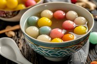 Colorful traditional glutinous rice balls floating in sweet syrup served in decorative bowl for Chinese New Year celebration dessert.