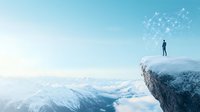 Silhouette of person standing on mountain cliff edge with glowing network connections above, overlooking snowy peaks and clouds in ethereal landscape.