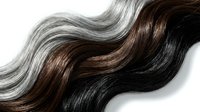 Flowing wavy hair strands in natural brown, black and silver gray colors isolated on white background for beauty and haircare design concepts.