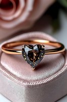Rose gold engagement ring with heart-shaped smoky quartz gemstone on pink silk background with soft rose bokeh, elegant jewelry photography for luxury retail.