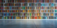 Modern library interior with colorful books arranged on white shelves spanning entire wall, viewed from empty floor space.