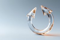Modern minimalist ring with arrow-shaped ends in rose gold and clear acrylic design, photographed on light gray background with soft shadows and reflections.