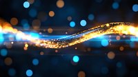 Magical glowing wave with golden sparkles and blue bokeh lights on dark background creates dreamy atmosphere for festive designs and celebrations.