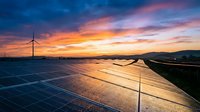 Solar panels and wind turbine at sunset, renewable energy farm generating clean power for sustainable electricity production and environmental conservation.