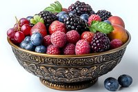Fresh mixed berries including raspberries, blackberries, blueberries and red grapes arranged in ornate vintage bronze bowl with decorative floral pattern.