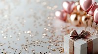 Festive gift box with bronze ribbon and rose gold balloons on sparkly background for birthday party celebration decorations.