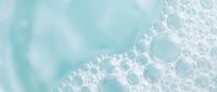 Abstract turquoise water surface with white foam bubbles creating organic patterns. Soft aqua background perfect for spa, wellness, beauty treatments.