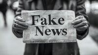 Person holding newspaper with fake news headline in black and white, highlighting media misinformation and propaganda concept. Focus on text against blurred background.