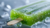 Fresh green popsicle with wooden stick covered in water droplets on ice cubes, showcasing refreshing summer treat for food marketing.