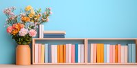 Colorful books arranged on wooden shelves against turquoise wall with fresh spring flowers in terracotta vase, creating modern minimalist home library setting.