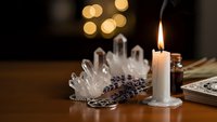 Mystical crystal cluster with burning candle creates atmospheric spiritual ambiance for meditation, healing practices, and esoteric rituals setup.