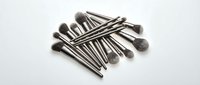 Professional makeup brush set with silver handles arranged on white background for beauty and cosmetics applications.