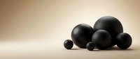 Black spheres of various sizes arranged on neutral beige surface creating minimalist geometric composition for modern design projects and contemporary decor.