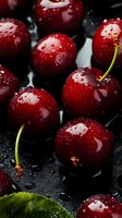 Fresh ripe dark red cherries with water drops on black background, macro shot showing juicy texture and natural stems for food photography and design.