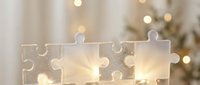 White wooden puzzle pieces with warm golden lights creating cozy atmosphere for teamwork and problem-solving concepts during holiday season.
