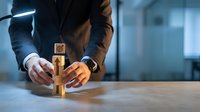 Business professional arranging wooden blocks with target symbol on office desk, strategic planning and goal achievement concept for corporate success.