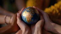 Hands holding small globe model with golden continents on blue oceans background, representing unity, environmental care and global connection concept.