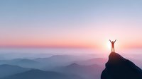 Silhouette of person with raised arms standing on mountain peak at sunrise, overlooking misty mountain ranges in purple and blue hues.