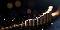 Metallic cylinders arranged in ascending order creating dynamic composition with warm bokeh lights and reflective surface, dramatic lighting for business concept.