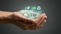 Cupped hands holding glowing green environmental sustainability icons including renewable energy, recycling and conservation symbols for eco-friendly business concepts.