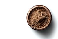 Loose mineral makeup powder in open brown container on white background with soft shadow, natural cosmetic product for beauty and skincare.