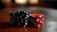 Stacks of black and red poker chips on dark wooden table with dramatic lighting and shallow depth of field, creating atmospheric casino ambiance.