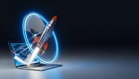 Rocket launching from laptop screen with glowing blue light trails creating dynamic circular motion effects on dark background for technology and startup concepts.