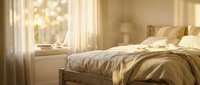 Serene bedroom with golden sunlight streaming through sheer curtains, illuminating a neatly made bed with warm bedding and pillows near a bright window for relaxation and sleep design.