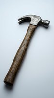 Vintage claw hammer with weathered wooden handle and metal head isolated on white background for construction and carpentry projects.