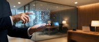 Businessman in dark suit holding glowing digital hologram with network connections and data visualization in modern office environment with warm lighting.