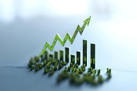 Growing bar chart with upward green arrow trend showing business growth and success statistics on blurred background with selective focus.
