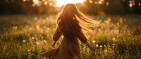 Young woman with flowing hair dancing freely in golden sunset meadow with warm bokeh lights creating magical atmosphere for wellness and joy concepts.