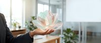 Businesswoman holding glowing holographic lotus flower in modern office with plants and windows, representing wellness, growth, and digital transformation for corporate design.