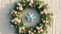 Spring floral wreath with pink roses, eucalyptus and ferns surrounding blue Easter eggs on rustic linen background for seasonal home decor and celebrations.