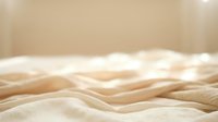 Soft beige fabric waves creating elegant textile background with gentle folds and smooth curves for luxury interior design and fashion projects.