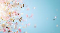 Festive pink and gold confetti floating against soft blue background creates magical celebratory atmosphere for party, wedding, or special event designs.