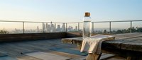 Urban rooftop with water bottle and city skyline view, suitable for lifestyle, wellness, and urban living concepts.
