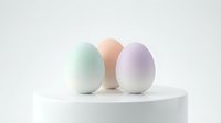 Three pastel colored eggs in mint green, peach and lavender arranged on white cylindrical platform against neutral background for Easter decor.