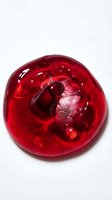 Translucent red gel sphere with organic bubble formations inside, isolated on white background. Perfect for cosmetics, skincare, beauty product packaging, and scientific visualization designs.