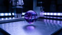 Glowing purple sphere with reflective surface on illuminated platform, surrounded by neon lights, suitable for technology and futuristic design projects.