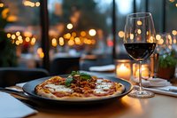 Elegant pizza and red wine dinner at upscale restaurant with warm ambient lighting and city view background for romantic dining experience.