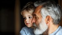 Tender moment between senior man with gray beard and young child showing loving bond and family connection against dark background, side view portrait.